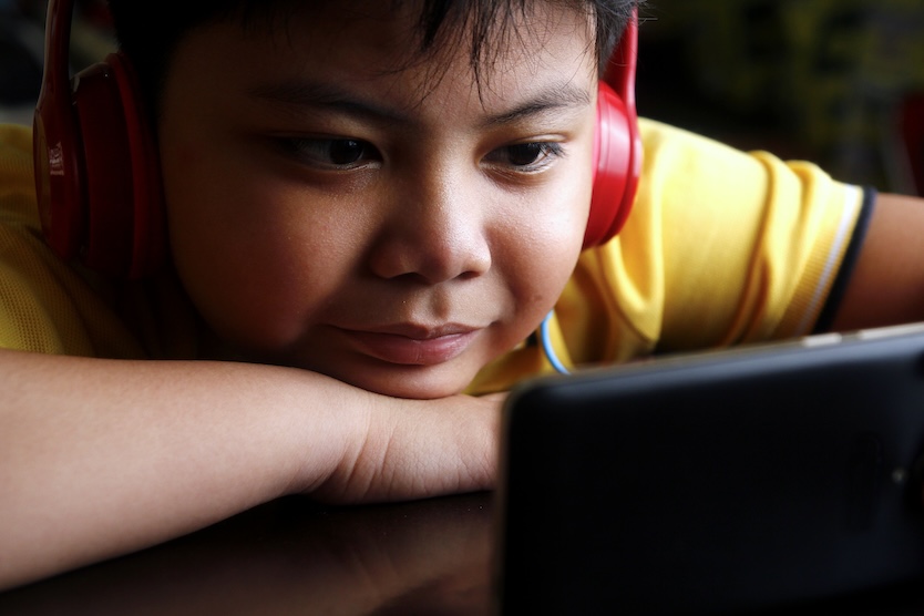 Young Asian boy with a smartphone and headphones